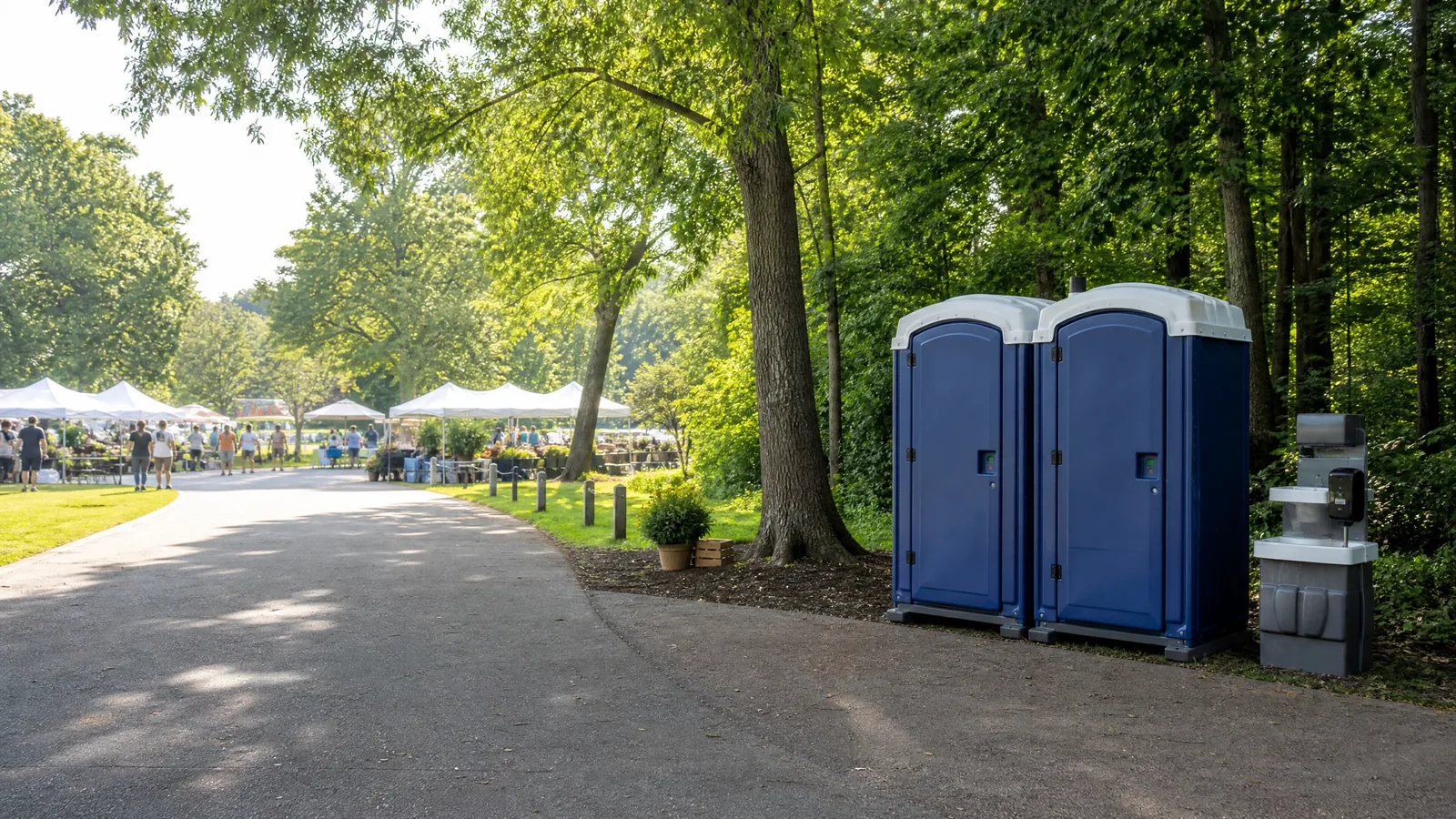 Clean portable restrooms positioned beside a community market walkway.